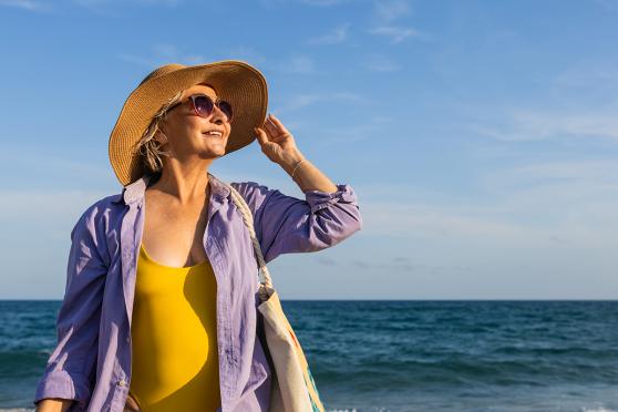 A woman smiling with a body of water behind her