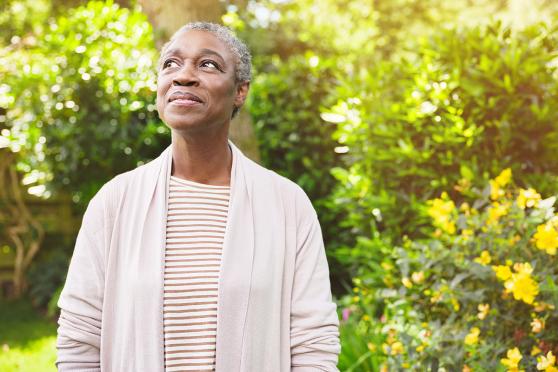 A woman standing outside and gazing to the side